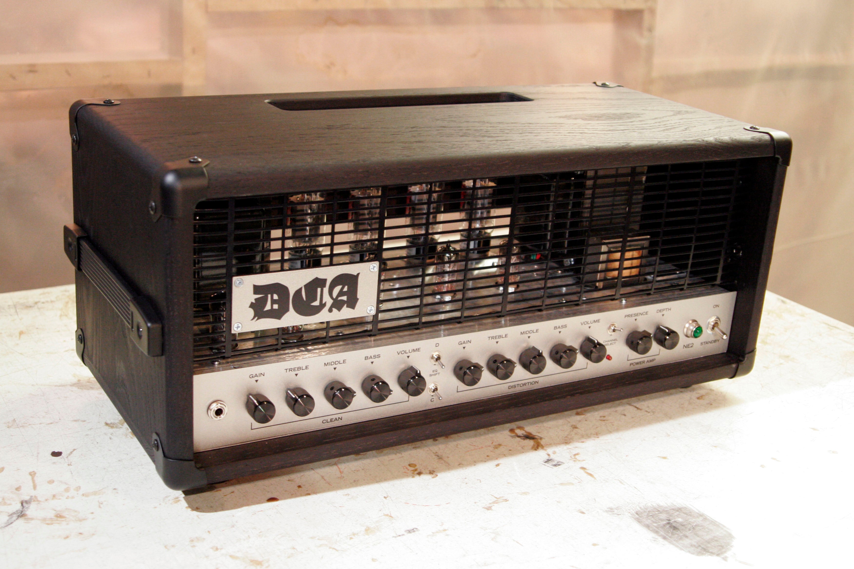 Guitar amplifier head with 'DCA' branding on a metal grill.